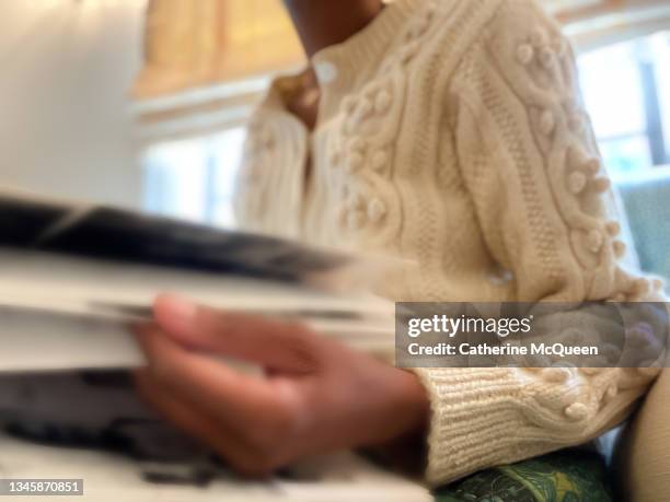 african-american woman reminiscing by perusing an old school yearbook - vintage yearbook stock pictures, royalty-free photos & images