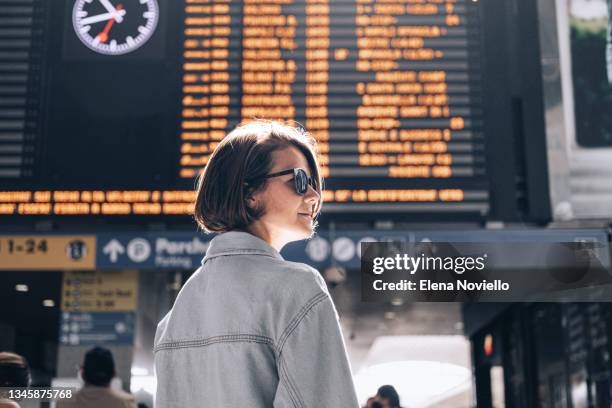 a young woman at a railway station or at the airport against arrival and departure board - 搭乗手続き ストックフォトと画像