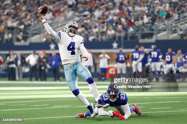 Dak Prescott of the Dallas Cowboys avoids a tackle by Logan Ryan of the New York Giants and throws the ball to Ezekiel Elliott of the Dallas Cowboys...