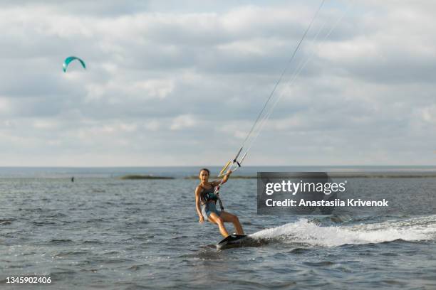 young woman enjoying her kitesurfing success. - kite surf stock-fotos und bilder