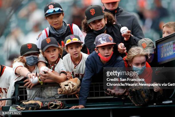 Young San Francisco Giants' fans try to get the attention of a player before Giants play Los Angeles Dodgers in National League Division Series Game...