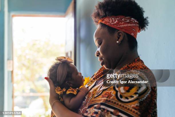 afrikanische mutter hält das baby auf dem schoß - black man holding baby stock-fotos und bilder