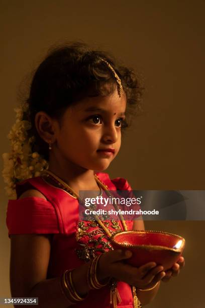 young indian girl holding diwali oil lamp - three fingers stock pictures, royalty-free photos & images