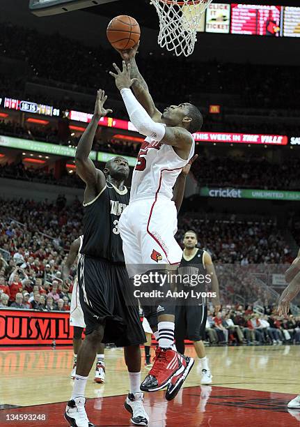 Chris Smith of the Louisville Cardinals shoots the ball while defended by Steve Tchiengang of the Vanderbilt Commodores during the game at KFC YUM!...