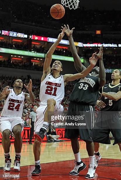 Steve Tchiengang of the Vanderbilt Commodores and Jared Swopshire of the Louisville Cardinals reach for a rebound during the game at KFC YUM! Center...