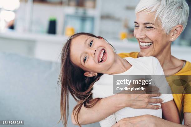 portrait of happy grandmother and granddaughter - head cocked stock pictures, royalty-free photos & images