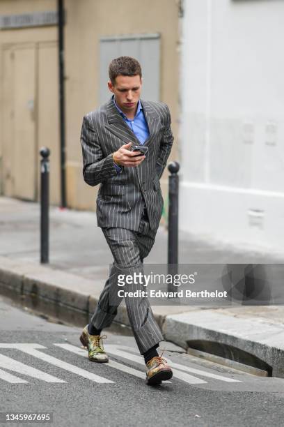 Guest wears a blue shirt, a gray striped blazer jacket, matching gray striped suit pants, black socks, green / yellow / white painted pattern leather...
