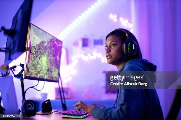 young black female gamer playing at night - desktop pc stock pictures, royalty-free photos & images