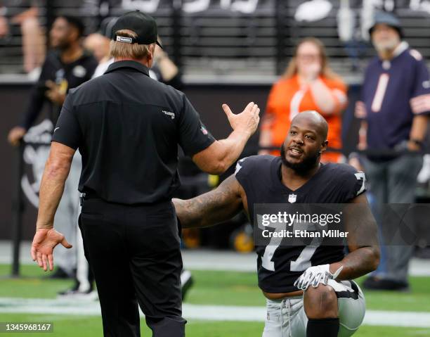 Head coach Jon Gruden of the Las Vegas Raiders greets defensive tackle Quinton Jefferson as he stretches before a game against the Chicago Bears at...