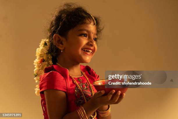 young indian girl holding diwali oil lamp - diwali stock pictures, royalty-free photos & images