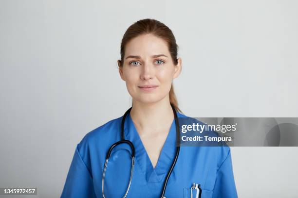 a female nurse looking at the camera. - nurse headshot stock pictures, royalty-free photos & images