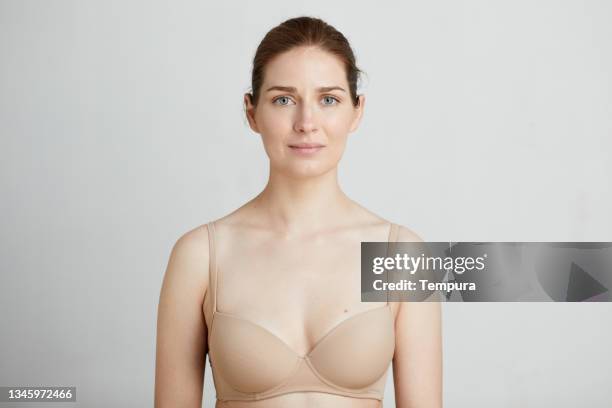 una mujer joven con un sostén de color de piel. - bra fotografías e imágenes de stock