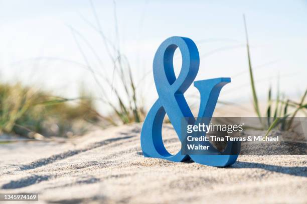 close up of an ampersand symbol on the beach. et-zeichen. - ampersand stock pictures, royalty-free photos & images