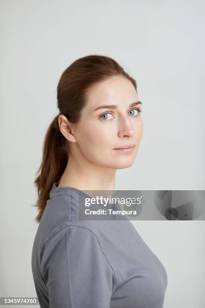 a young woman with blue eyes looking at the viewer. - three quarter front view stock pictures, royalty-free photos & images