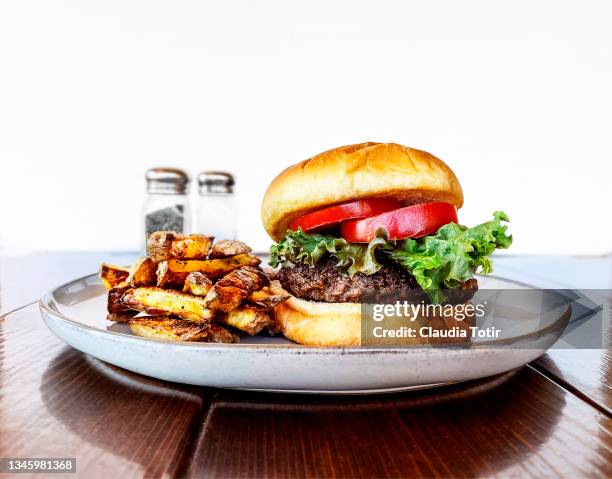 burger with french fries on a plate on white background - french fries white background stock-fotos und bilder