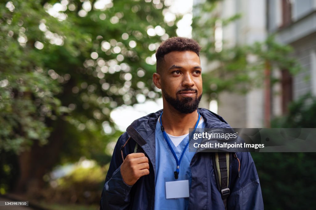 Man caregiver, male nurse or healthcare worker outdoors on the way to work.