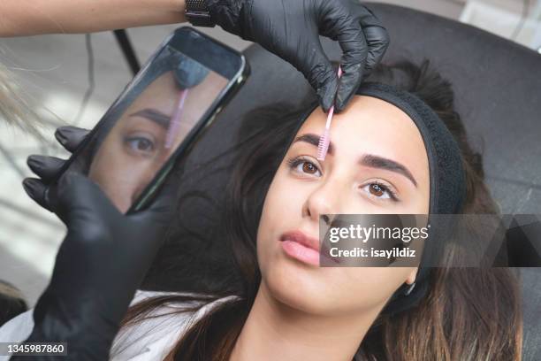 l’esthéticienne applique un maquillage permanent - maquillage permanent photos et images de collection