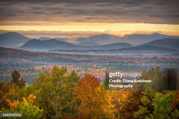 the sun breaks through the clouds and mist over the white mountains in new hampshire - appalachia stock-fotos und bilder