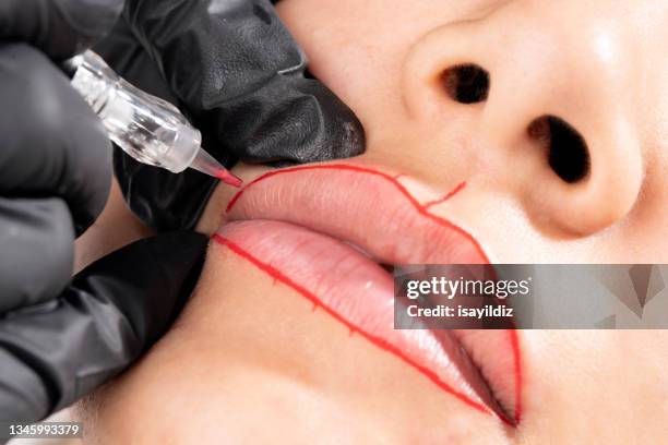 beautician is applying permanent make up - lip tattooing stock pictures, royalty-free photos & images