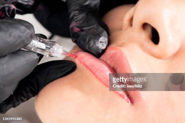 beautician is applying permanent make up - lippen stockfoto's en -beelden