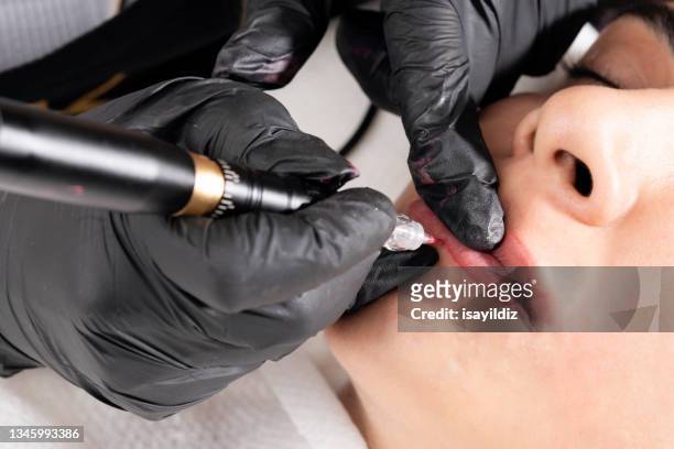 beautician is applying permanent make up - lip tattooing stock pictures, royalty-free photos & images