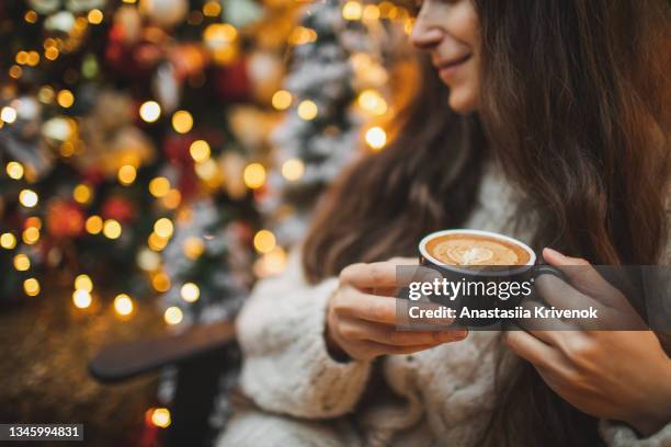 beautiful woman drinking hot chocolate or cocoa at the christmas market. - coffee christmas ストックフォトと画像