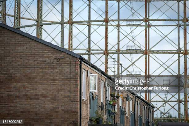 Disused gasometer stands behind homes on October 11, 2021 in Manchester, England. With the rise in wholesale gas costs, industry analysts predict...