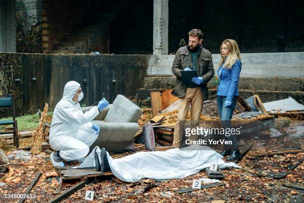 detectives and forensic analyst on a murder crime scene collecting evidence next to a dead body - dead body blood stock pictures, royalty-free photos & images