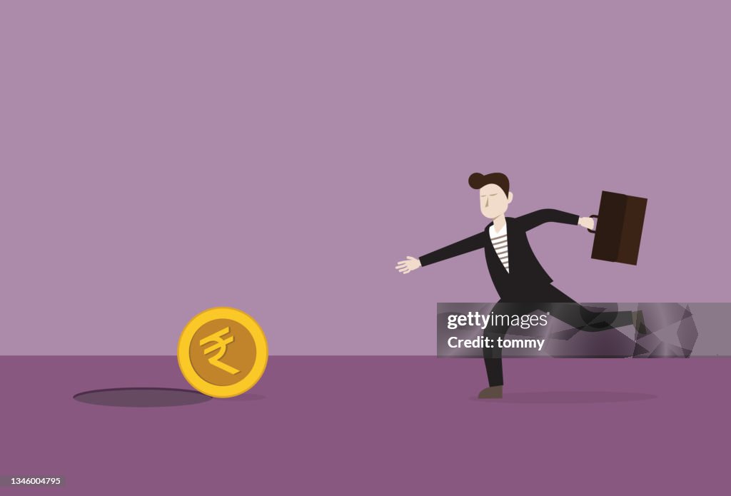 Businessman running to catch a India rupee coin