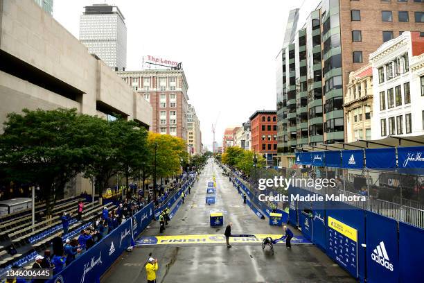 Marcel Hug of Switzerland crosses the finish line to win the men's wheelchair race during the 125th Boston Marathon on October 11, 2021 in Boston,...