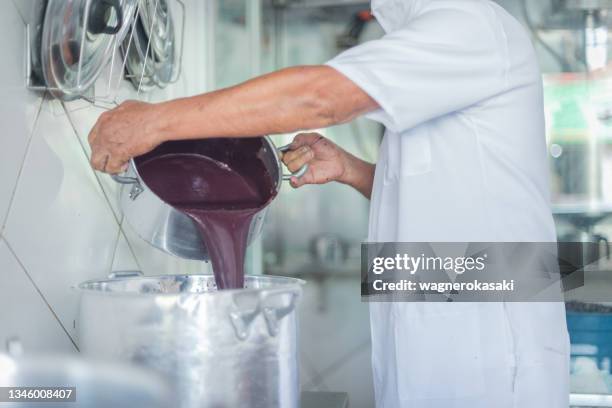 arbeiter, der gerade extrahiertes frisches acai-fruchtfleisch in eine pfanne gießt - kohlpalme stock-fotos und bilder