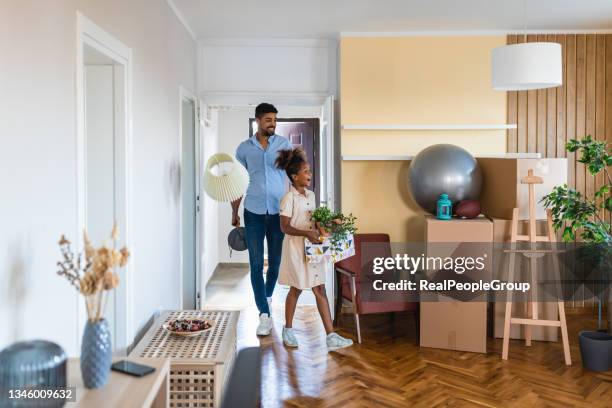 father and daughter enter a new house. - man with moving boxes authentic stockfoto's en -beelden