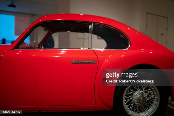 Viewers at the Museum of Modern Art look at a 1946 Pininfarina Cisitalia 202 GT automobile at the Automania exhibition October 10, 2021 in New York...