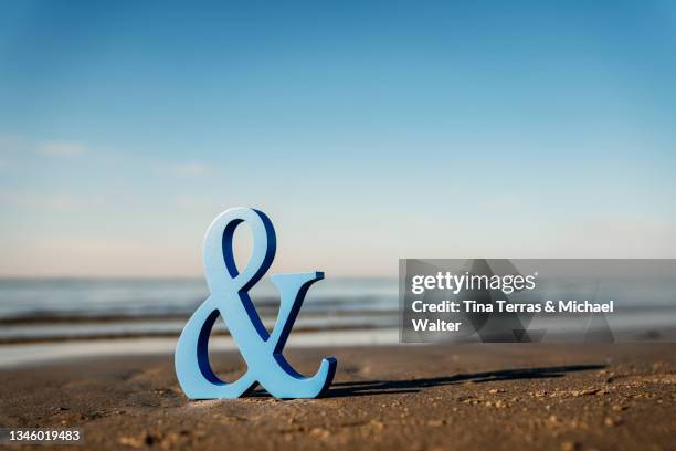 close up of an ampersand symbol on the beach. et-zeichen. - ampersand stock pictures, royalty-free photos & images