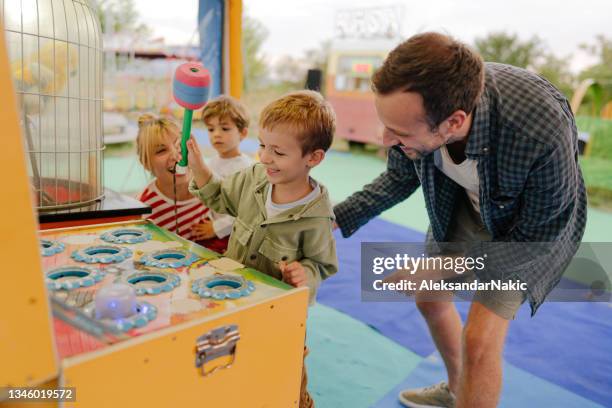 glückliche familie mit spaß auf der wandermesse - carnival game stock-fotos und bilder