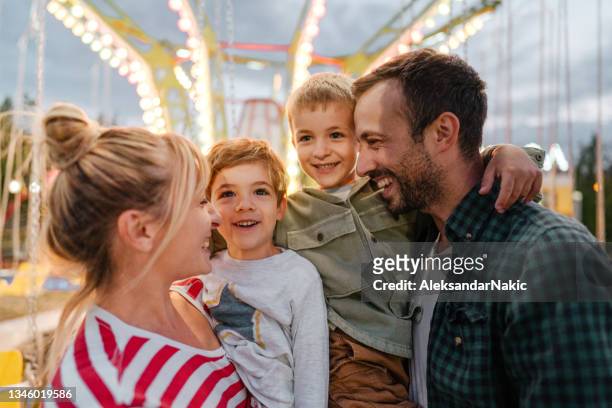 遊園地で幸せな家族 - 祭り ストックフォトと画像
