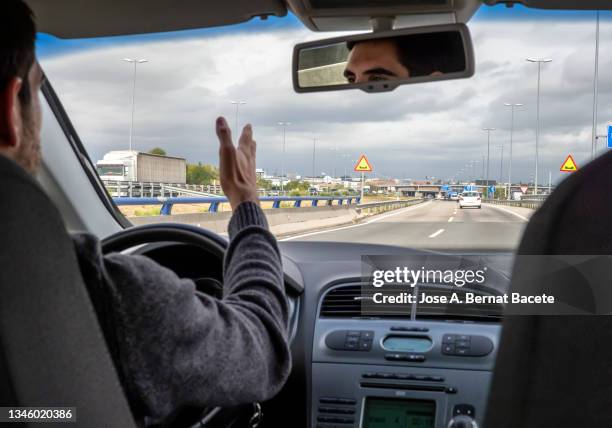 car point of view, nervous driver shouting in traffic jam on a two-lane highway. - dépasser photos et images de collection