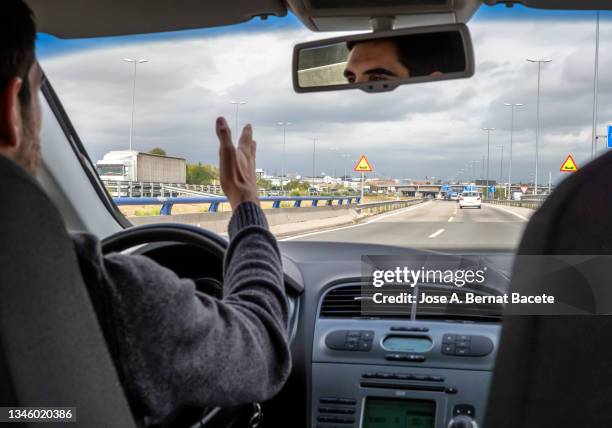 car point of view, nervous driver shouting in traffic jam on a two-lane highway. - single lane road - fotografias e filmes do acervo