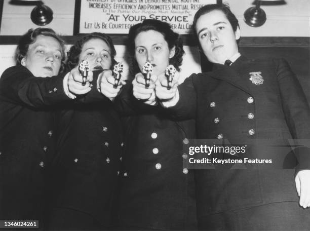 Uniformed female police officers of the New York Police Department in training, USA, circa 1935. Behind them is a sign which encourages courtesy to...