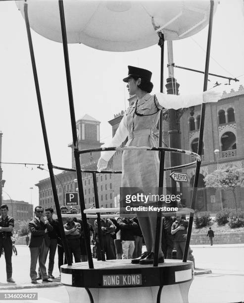 Nora Kiang, a female police officer from Hong Kong, directs traffic in front of the Arenas de Barcelona bullring on the Plaza de Espana in Barcelona,...