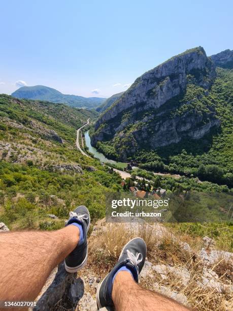 relaxing time on a ledge of a mountain with view at river below - climbs to all time high stock pictures, royalty-free photos & images