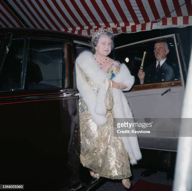 Queen Elizabeth the Queen Mother wearing a gold dress and a fur stole, circa 1970.