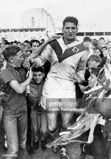 Rugby League player, Norm Provan, is surrounded by young admirers after Saint George beat South Sydney in the 1965 Grand Final.