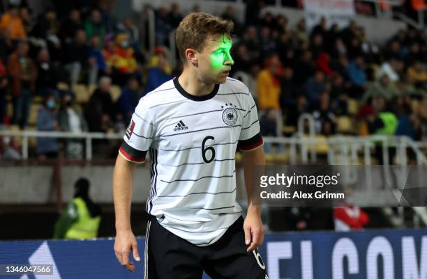 Joshua Kimmich of Germany has a laser pointer light shone onto his face during the 2022 FIFA World Cup Qualifier match between North Macedonia and...