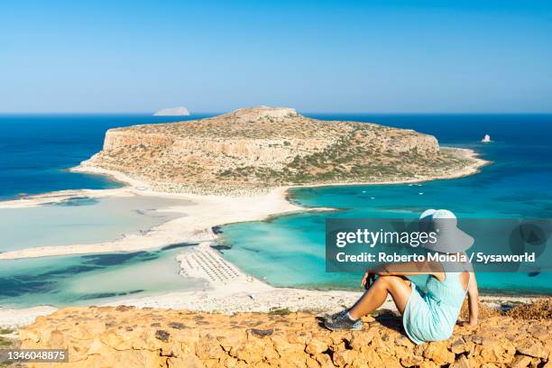young woman admiring balos lagoon, crete, greece - balonnen stock-fotos und bilder