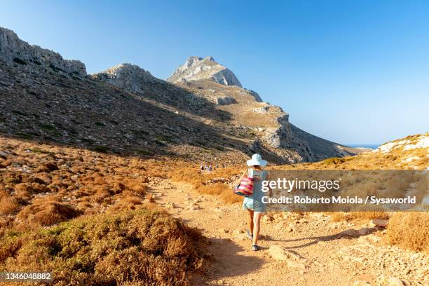 beautiful woman walking on footpath, crete island - balonnen stock-fotos und bilder