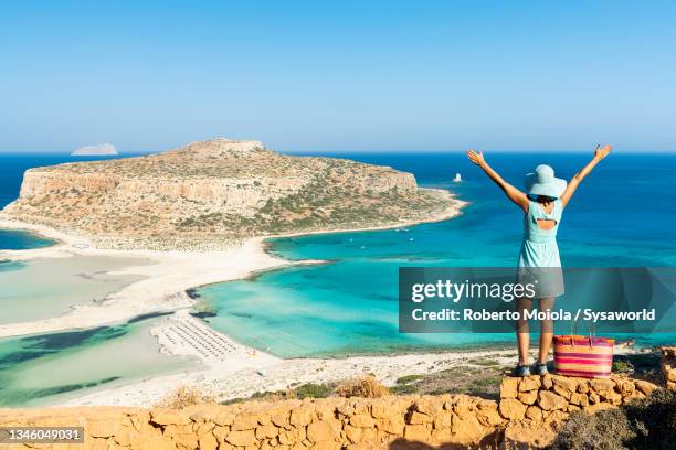 cheerful woman looking at crystal sea, crete - balonnen stock-fotos und bilder