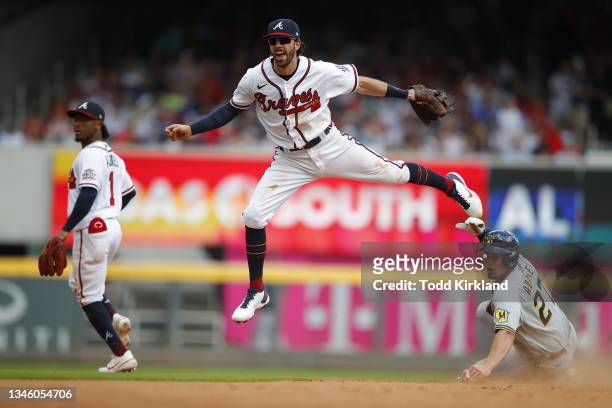 Dansby Swanson of the Atlanta Braves turns a double play during the eighth inning over Willy Adames of the Milwaukee Brewers in game 3 of the...