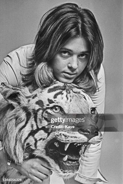 American singer-songwriter and musician Suzi Quatro poses with a stuffed tiger, UK, August 1973.