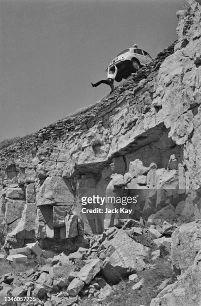 British actor and singer Michael Crawford struggles to support a Morris Minor on the edge of Seacombe Cliff in Dorset, during the filming of the...